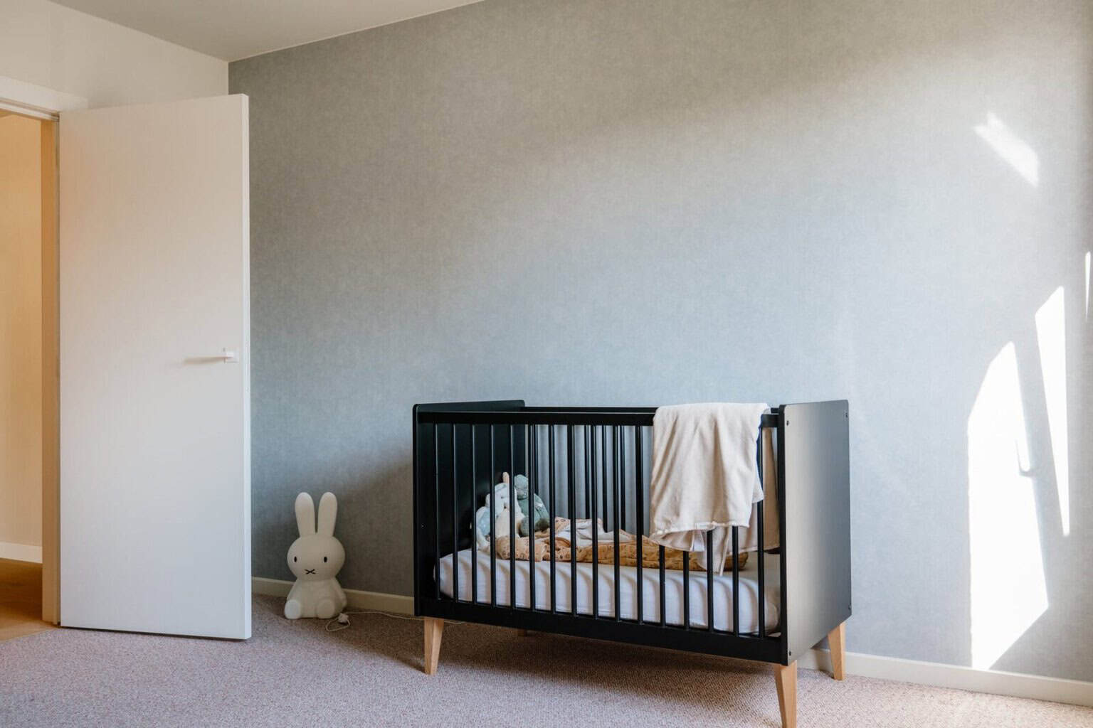 rustig grijsblauw behang in de babykamer bij de familie de wilde in lommel