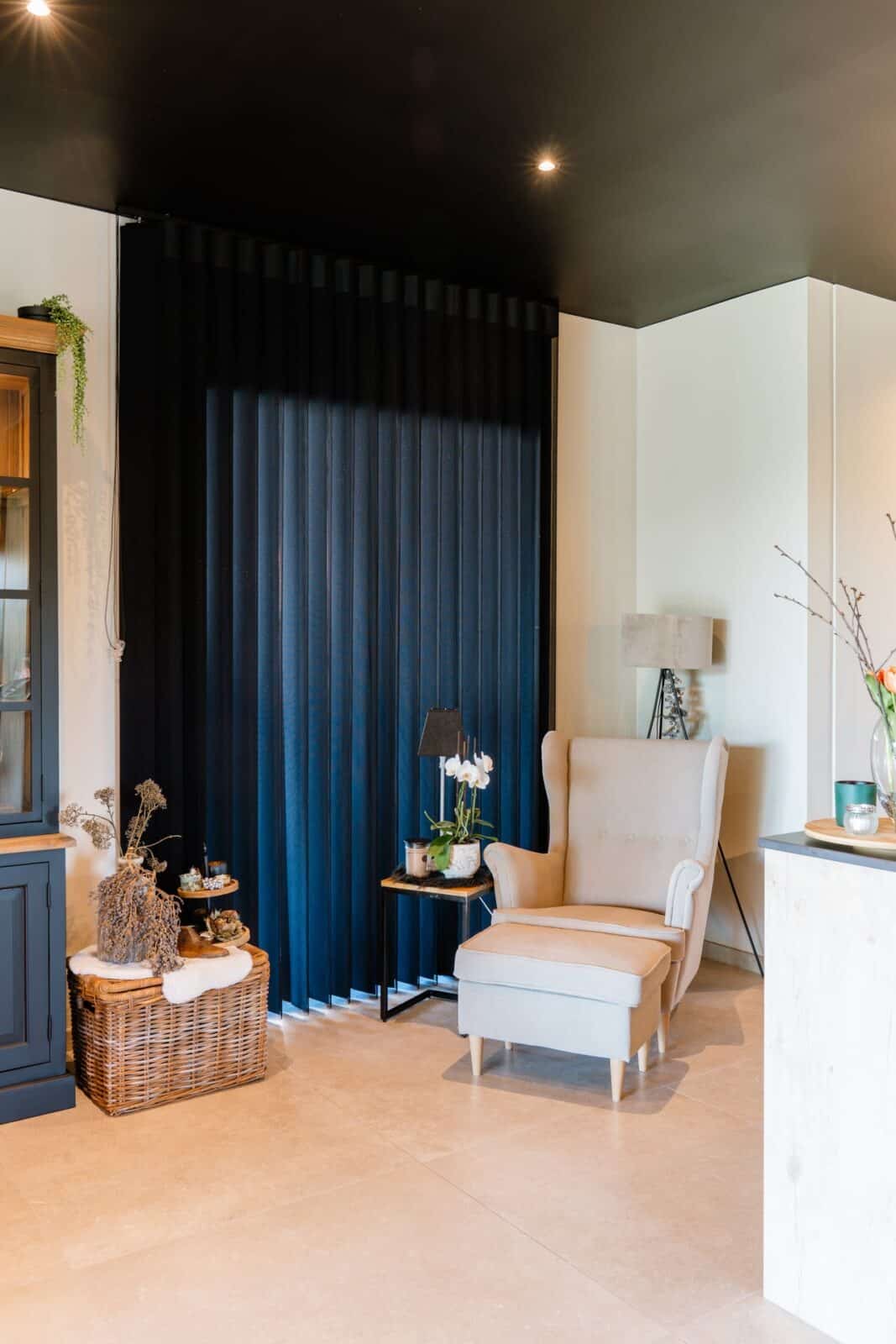 Zwarte Illusions lamellen gesloten naast lichte fauteuil en zwart plafond — woning Luyten
