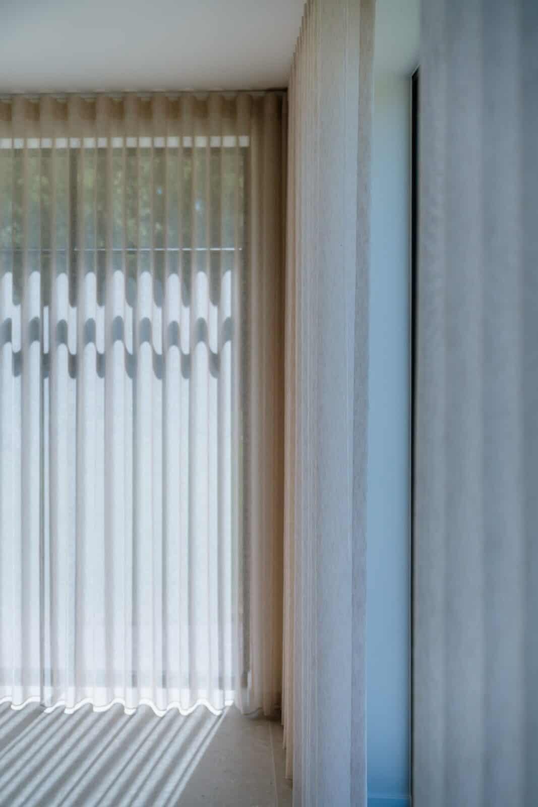 Detailopname wave gordijnen met lichtval door het stof - raamdecoratie woning Balen