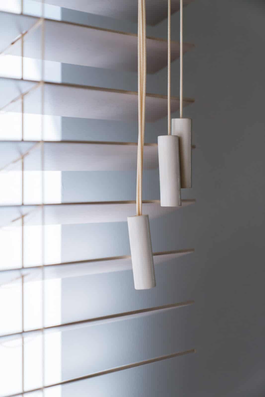 Close-up bediening houten lamellen met lichtinval — raamdecoratie Lommel