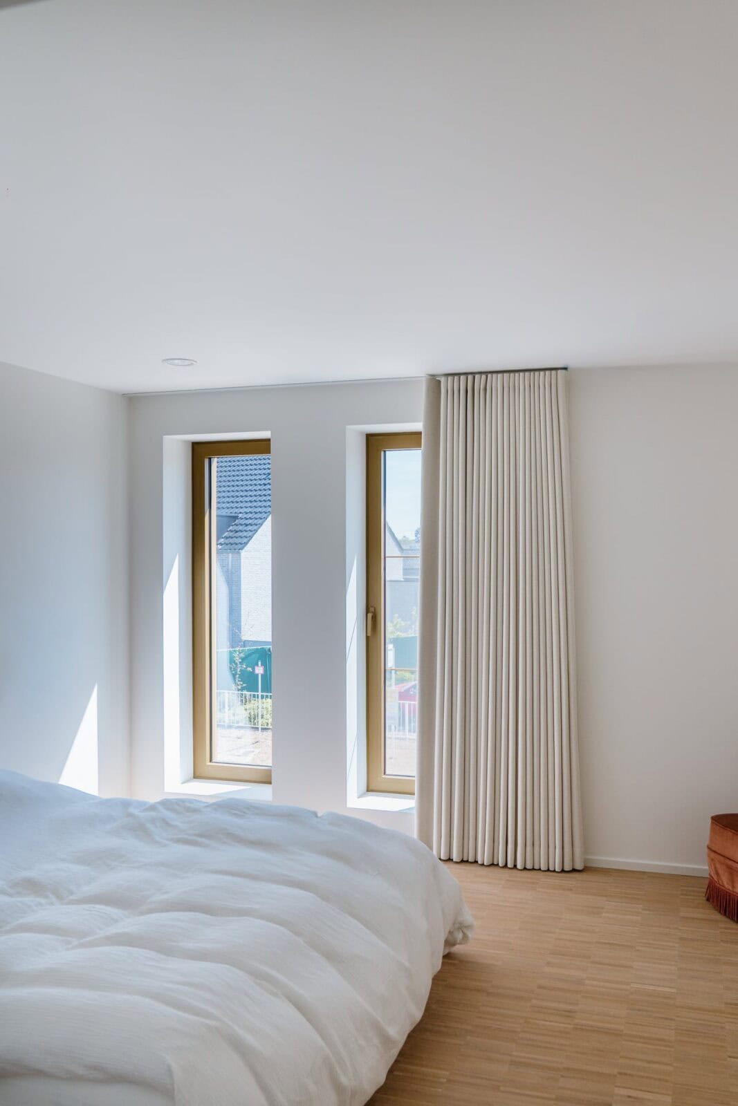 Wave gordijn naast twee ramen in witte slaapkamer — woning Lommel