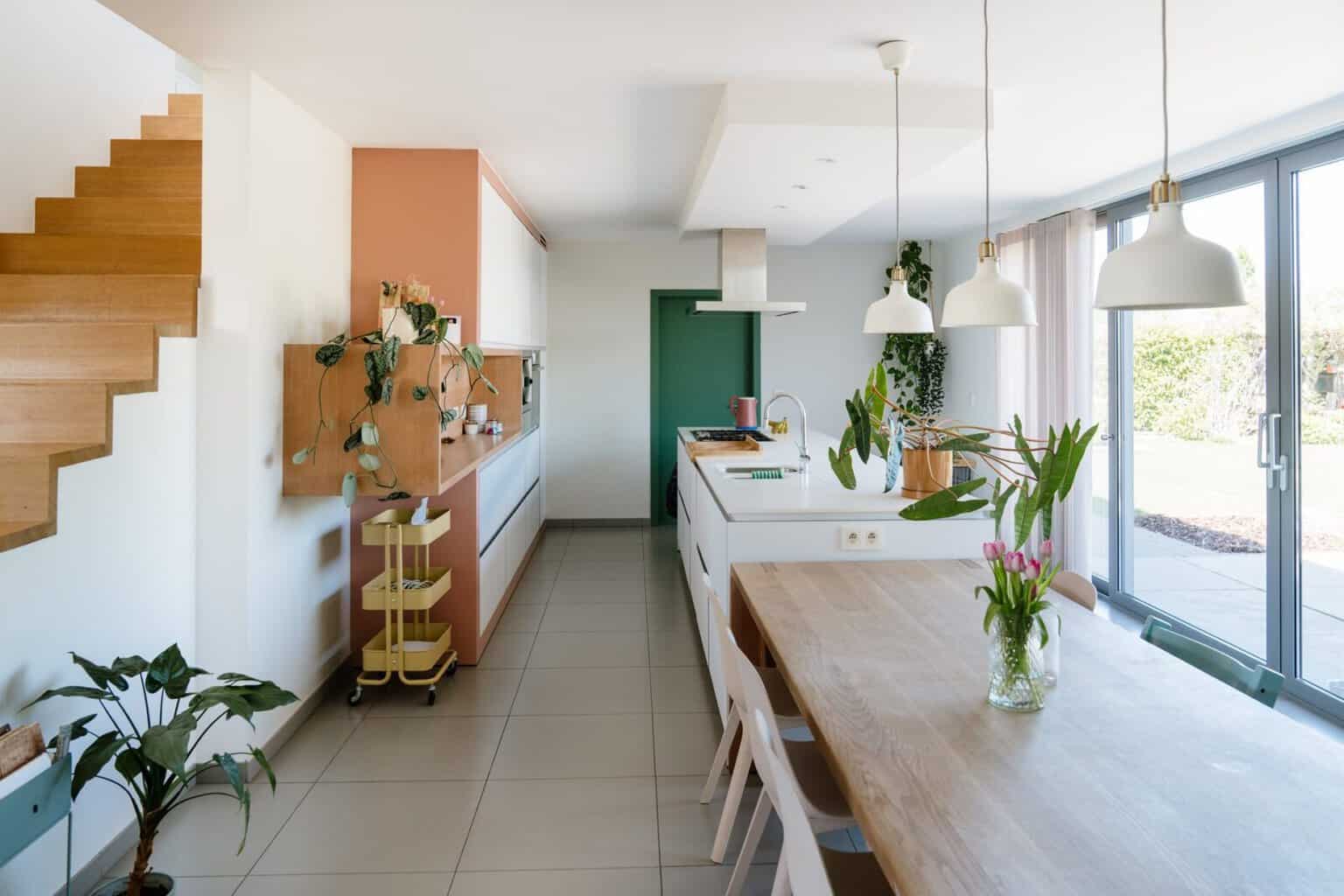 Overzicht keuken en eetruimte met terracotta kleuraccent en wave gordijn — woning Mol