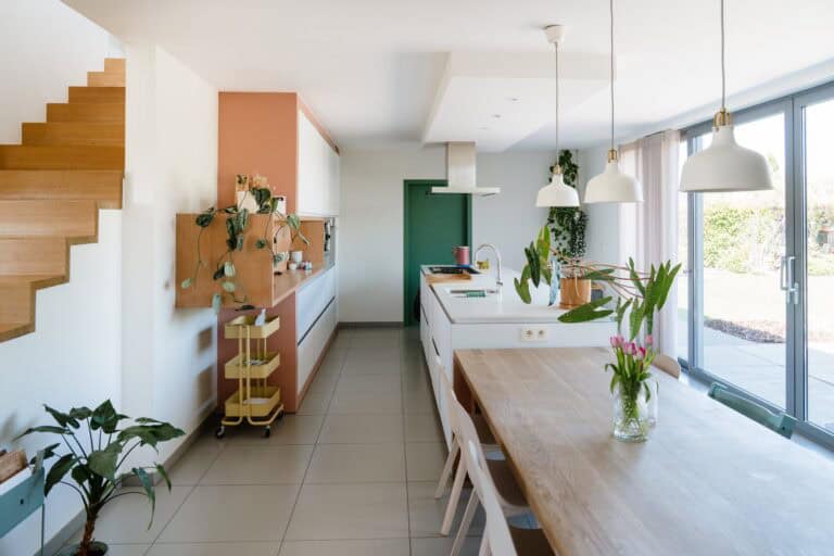 Overzicht keuken en eetruimte met terracotta kleuraccent en wave gordijn — woning Mol