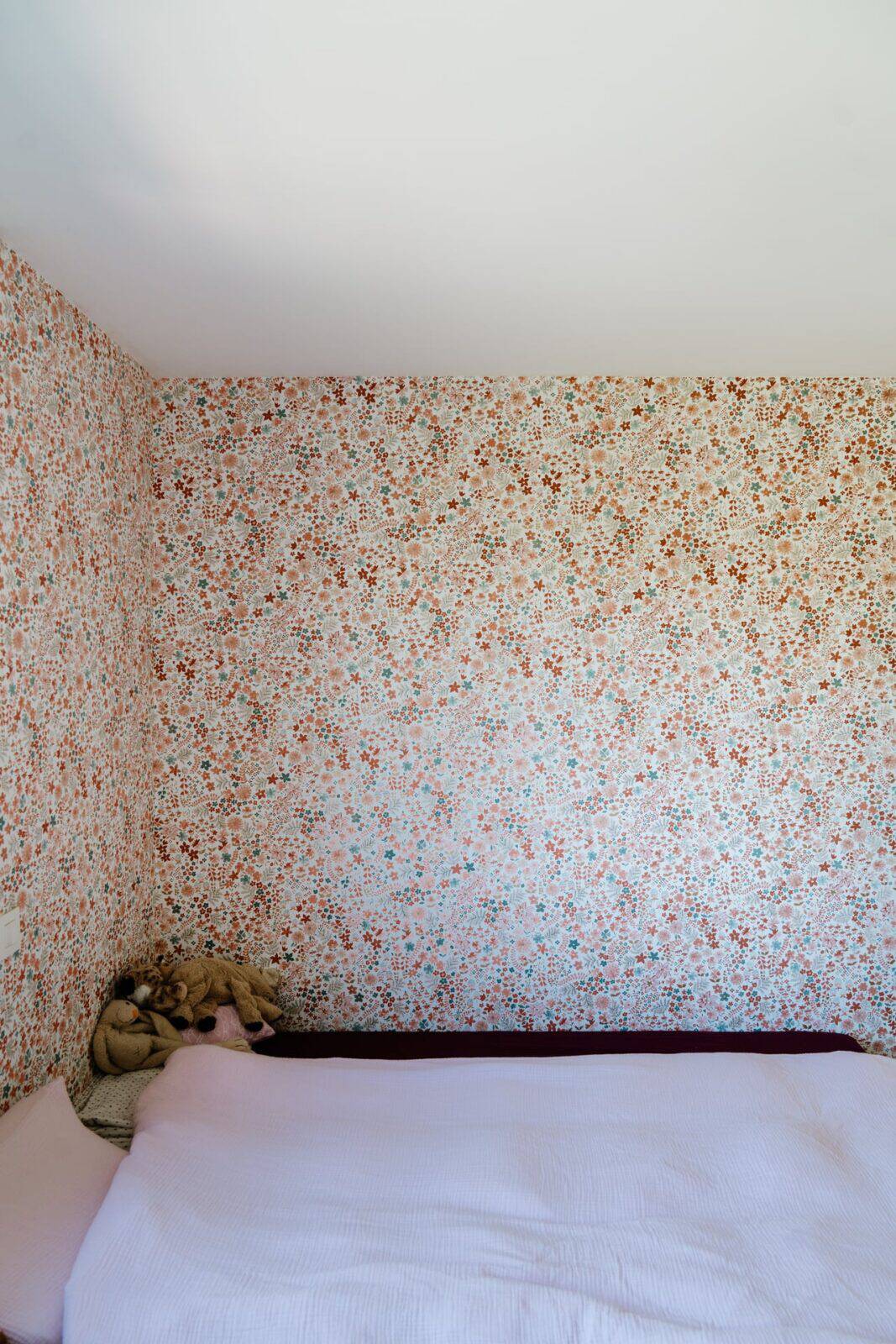 Kinderkamer met vrolijk bloemetjesbehang in roze, oranje en blauw — woning Mol