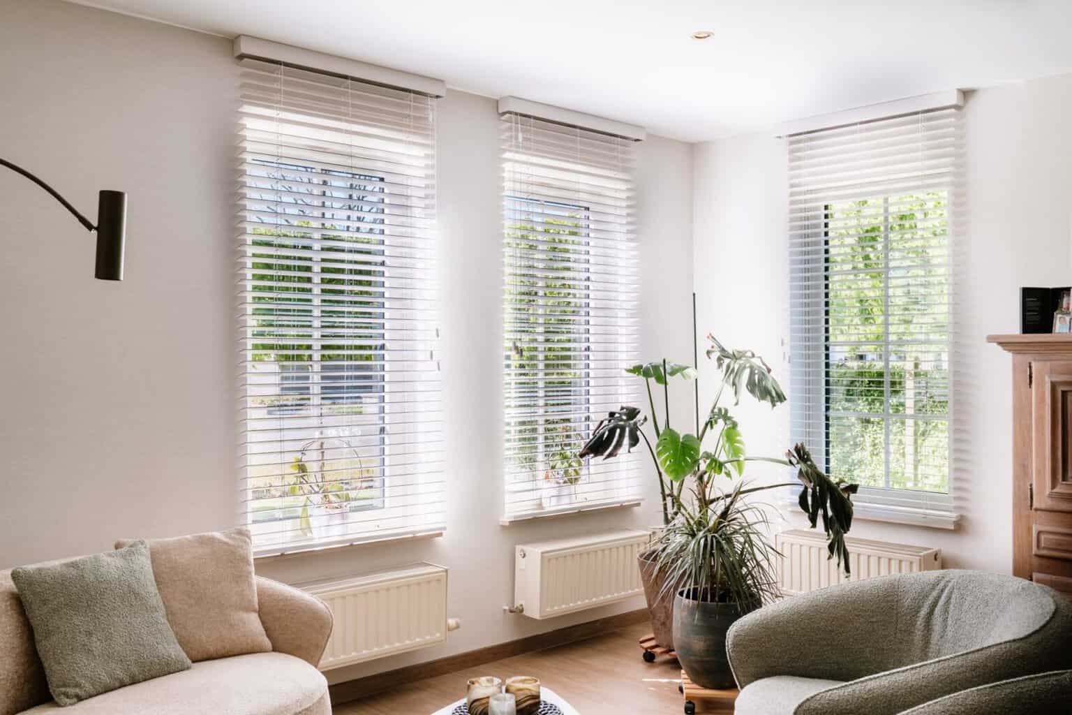 Witte houten lamellen over drie ramen in lichte living — woning Martens Pelt