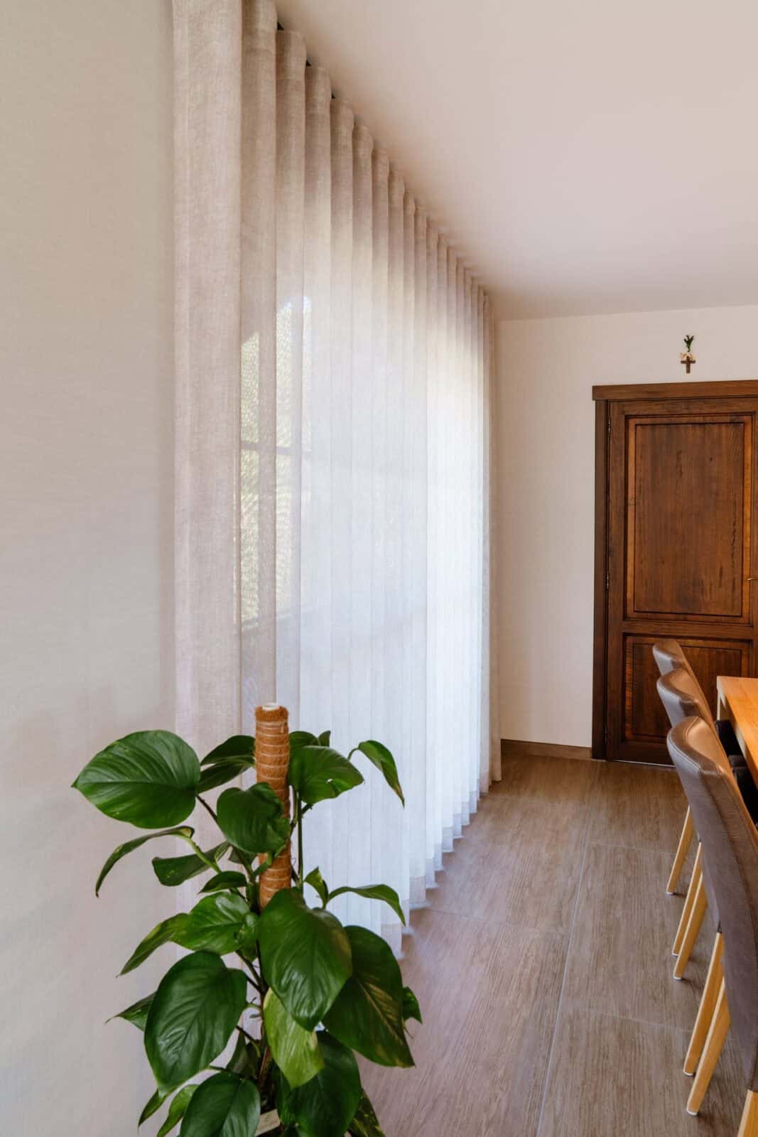Zijaanzicht transparant wave gordijn langs raamwand eetkamer — woning Pelt