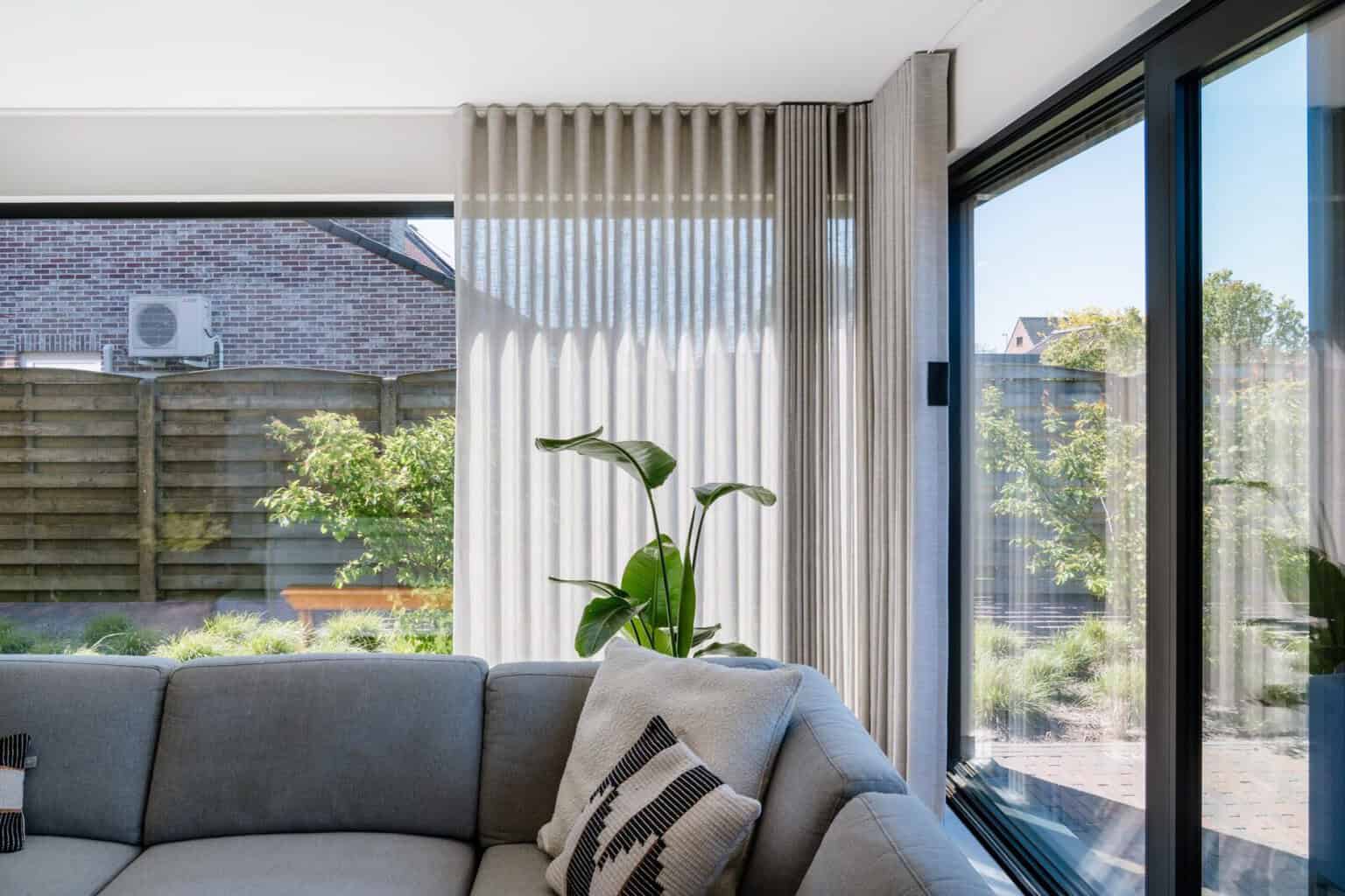 Wave gordijnen langs volledige raamwand in hoek van de living — woning Lommel