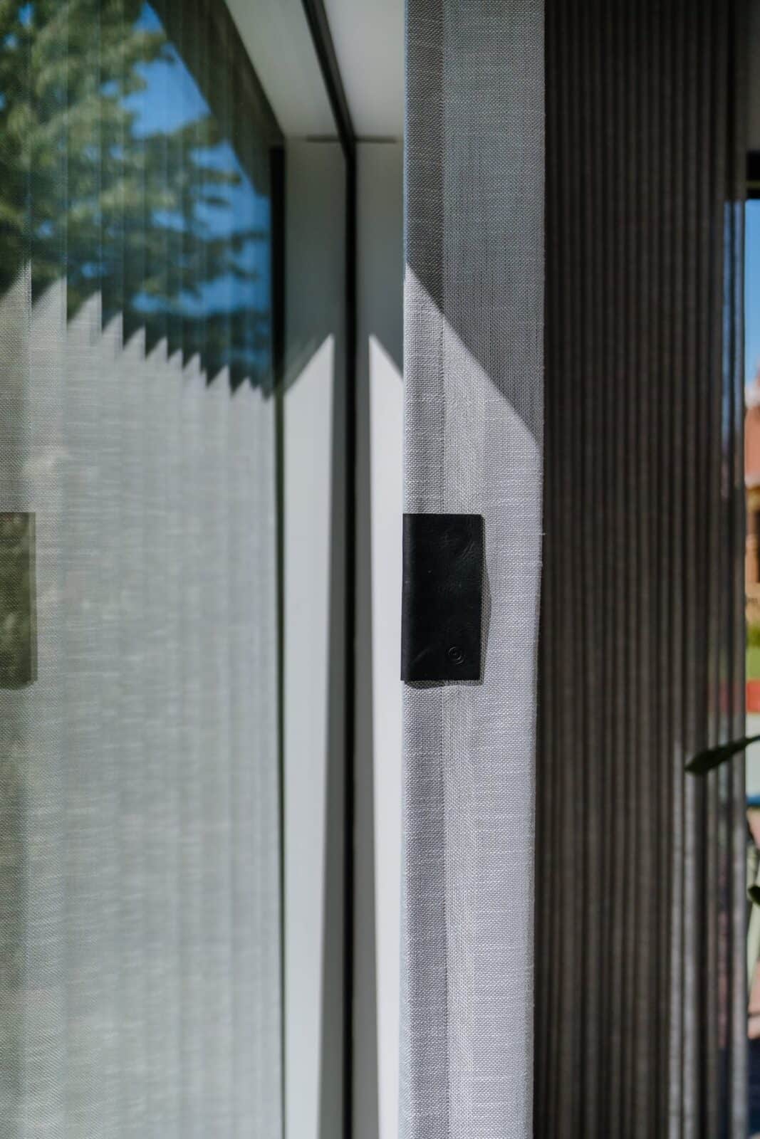 Detail transparante en verduisterende wave gordijnen langs raamhoek — woning Lommel