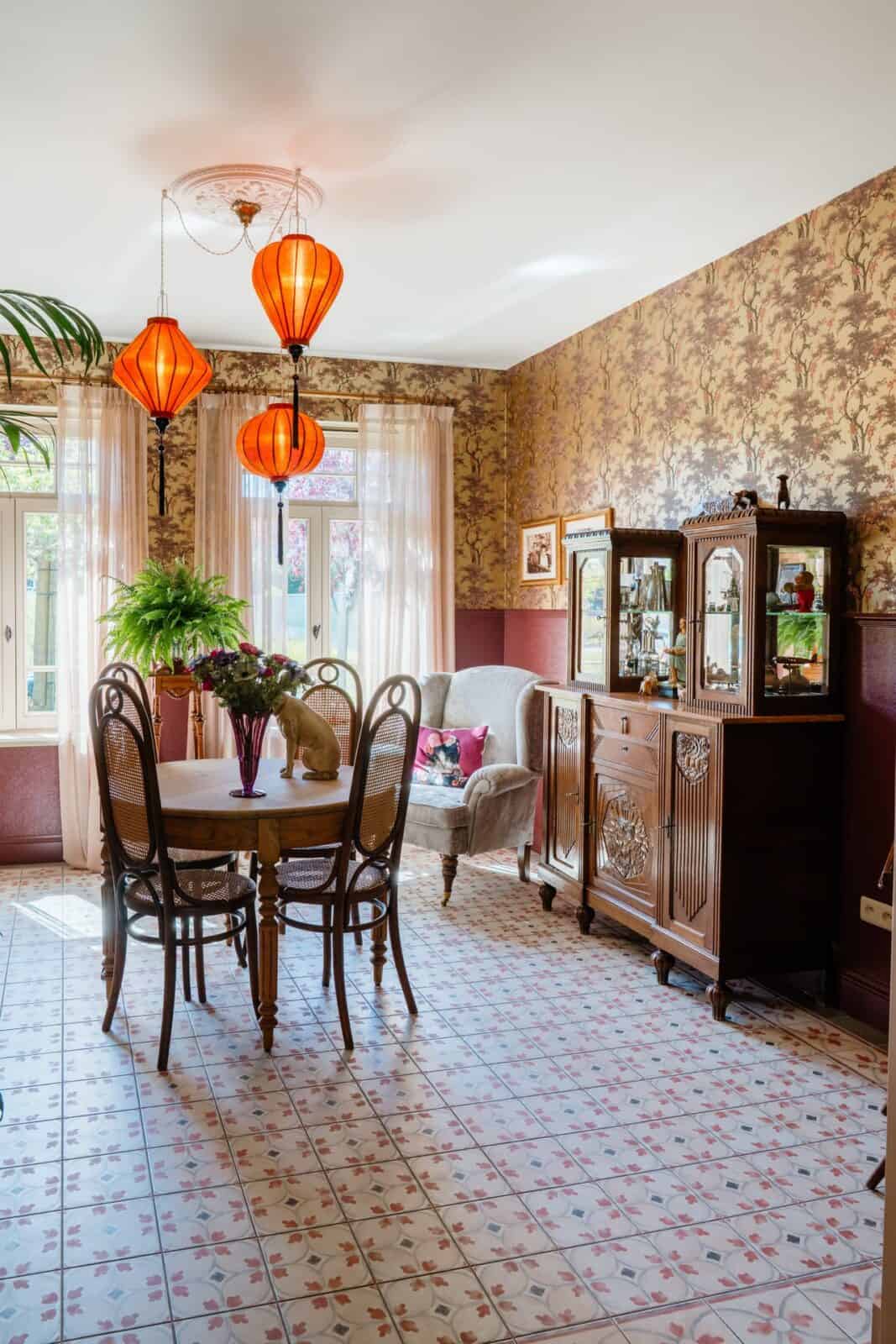 Botanisch boompatroon behang in okergoud met bordeauxrode lambrisering in eetkamer — woning Lommel