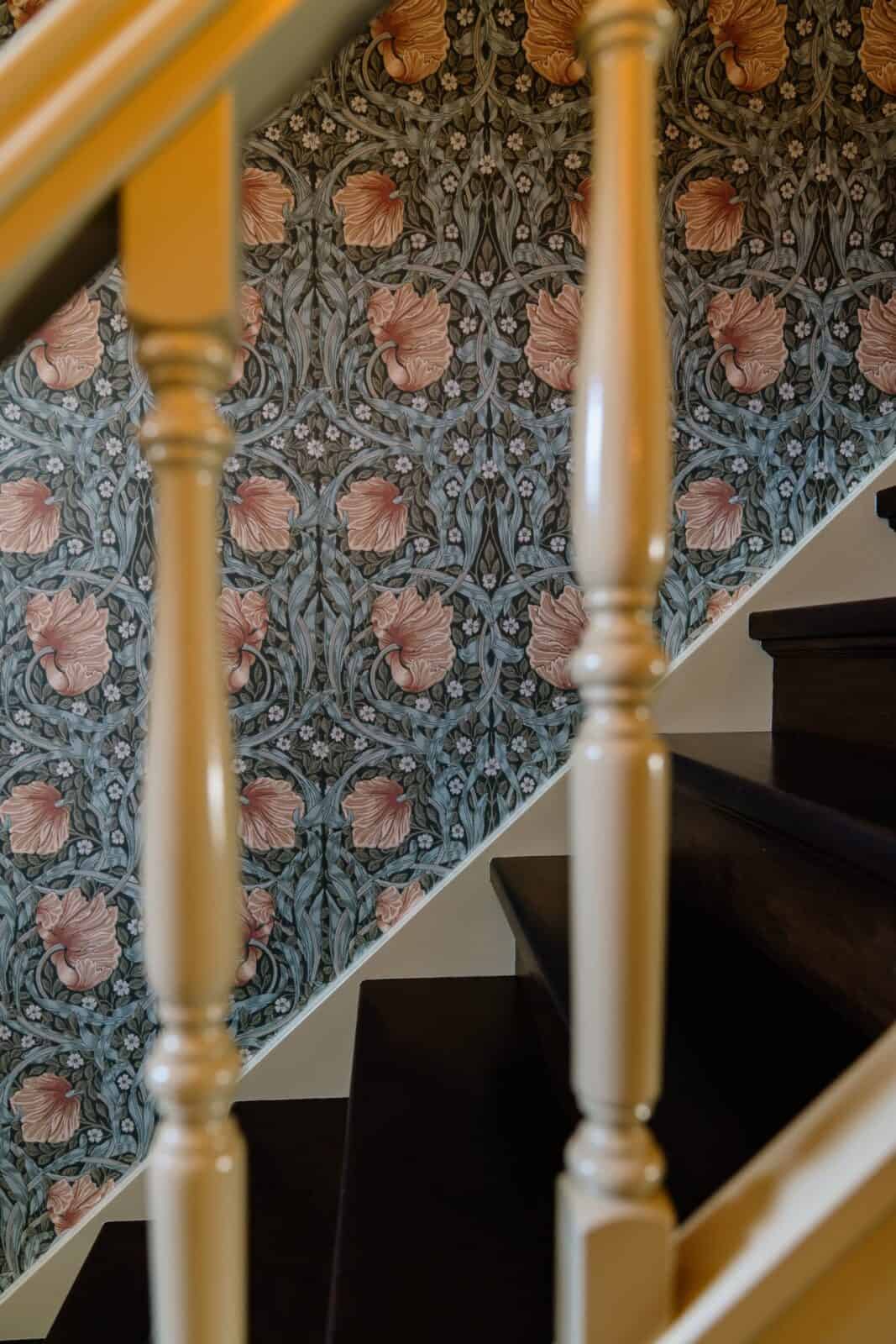 William Morris bloemen- en bladerbehang langs houten trapleuning — traphal woning Romers Lommel