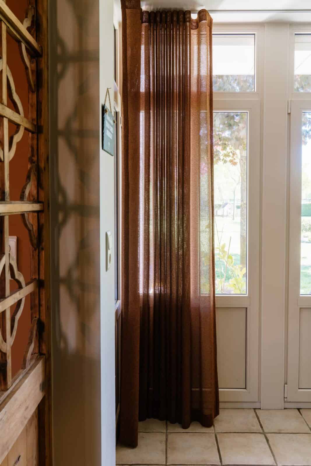 Detailopname roestbruine chenille gordijn met wave-effect in licht - hal woning Lommel