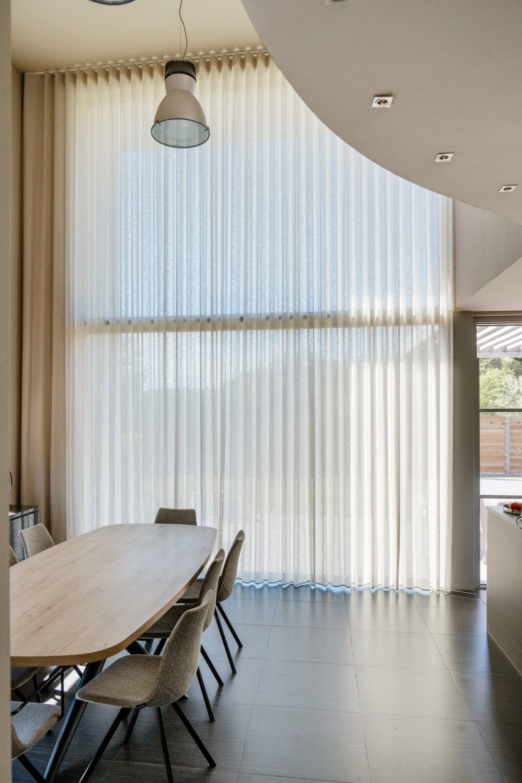 Lichtdoorlatend wave gordijn van vloer tot plafond in hoge vide — maatwerk raamdecoratie
